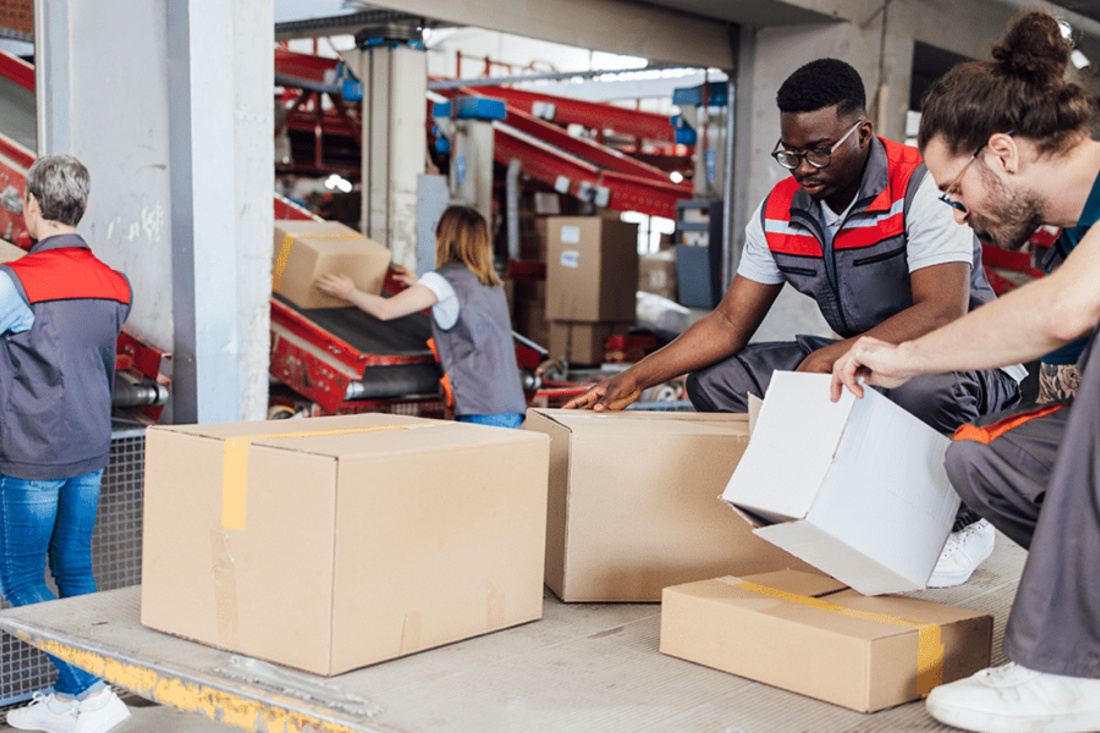 Workers in an information technology company's supply chain packaging up materials.