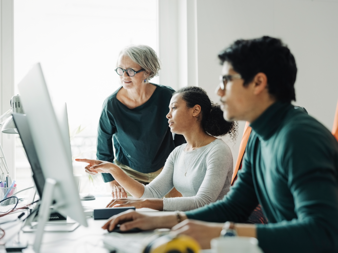 Group of co-workers looking at a computer