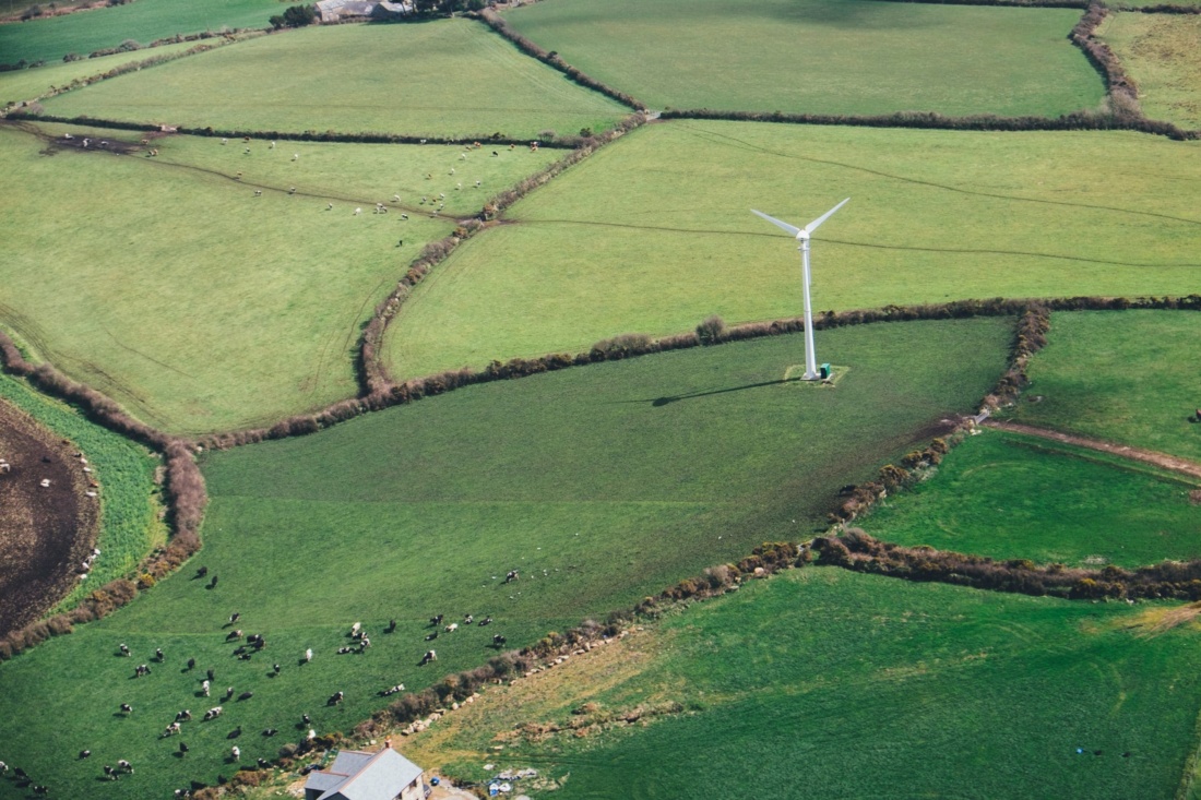 Wind turbine stands over green fields